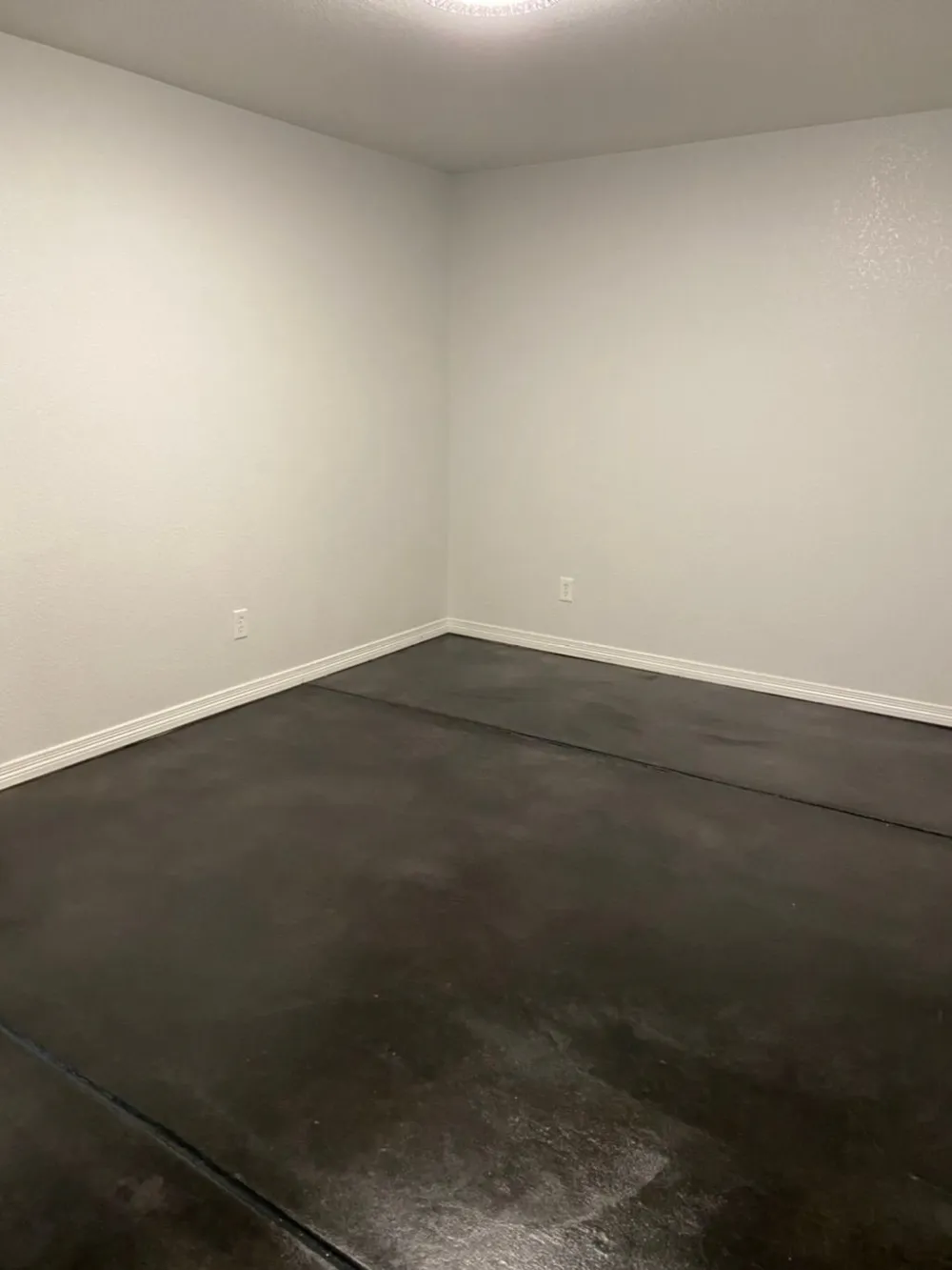 Stained concrete floor in a finished interior room, sealed with a satin sheen